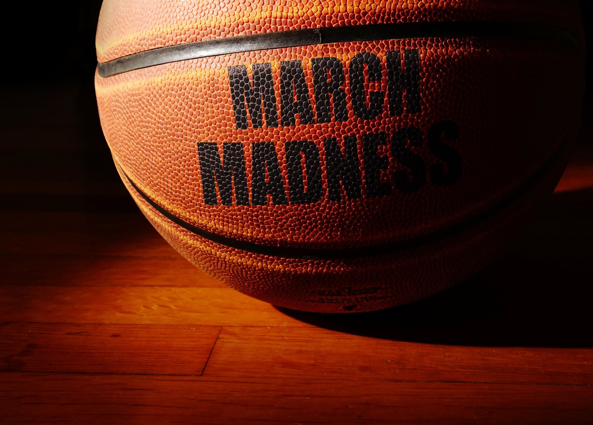 March Madness basketball on a hardwood court, college basketball tournament concept